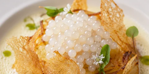 Les perles nacrées Famille Delage dressées dans une assiette de restaurant